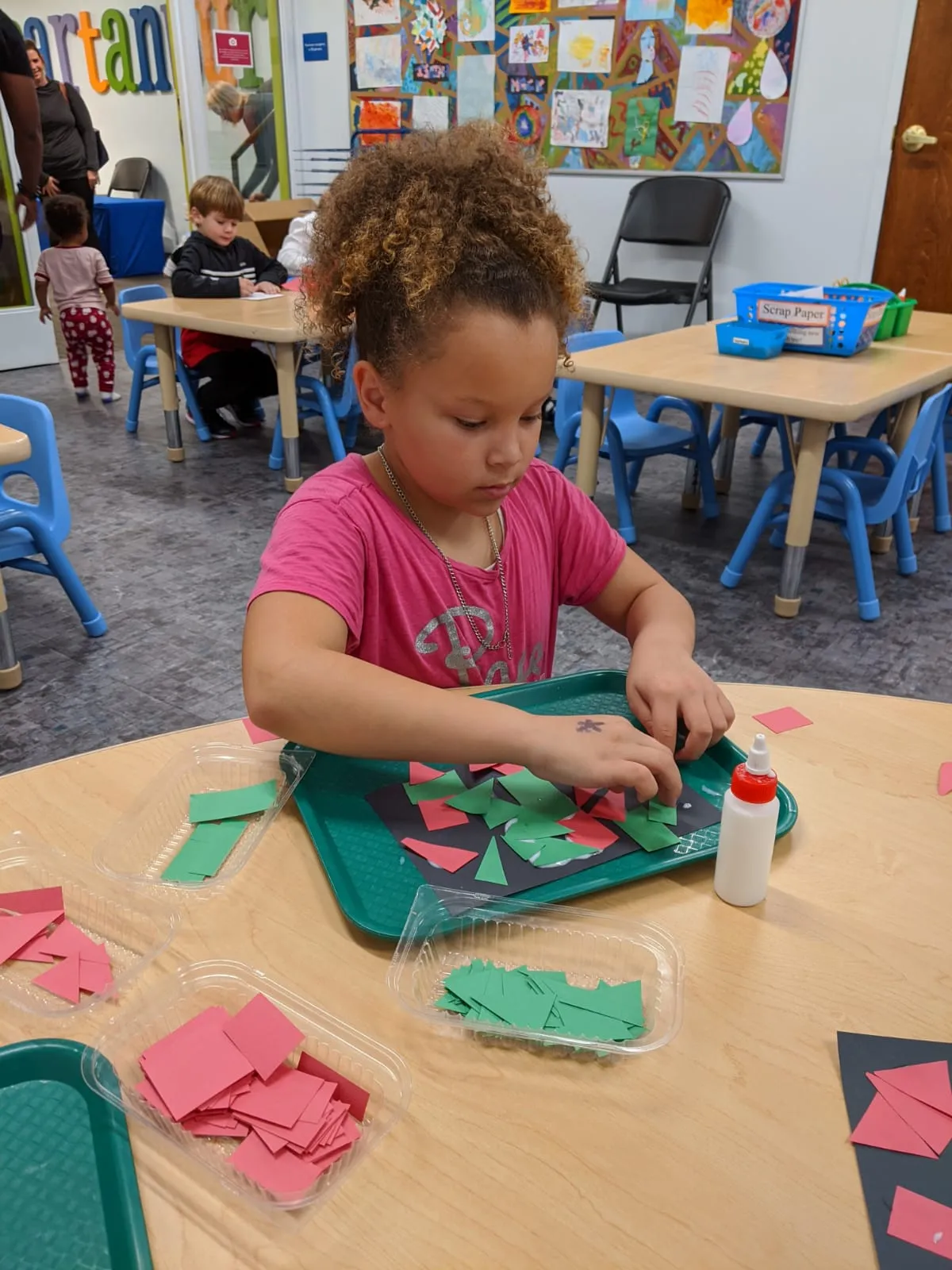 Girl making arts and crafts with paper and glue at the Children's Museum of the Upstate Spartanburg Location.