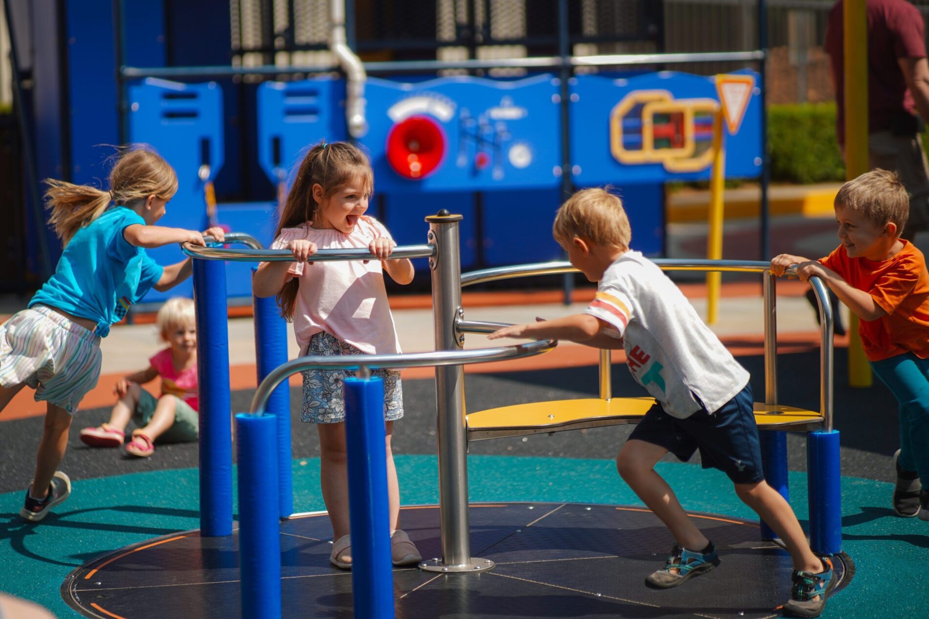 three children playing on a playground in a park