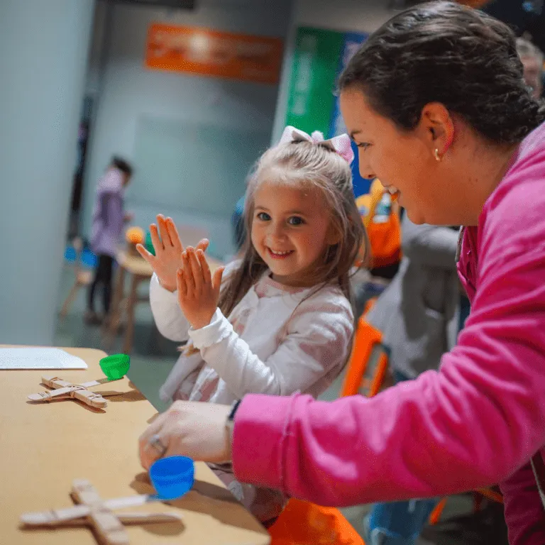 Mom and daughter making a wooden craft stick catapult.
