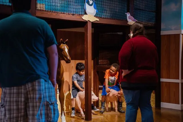 a group of people standing around a horse exhibit