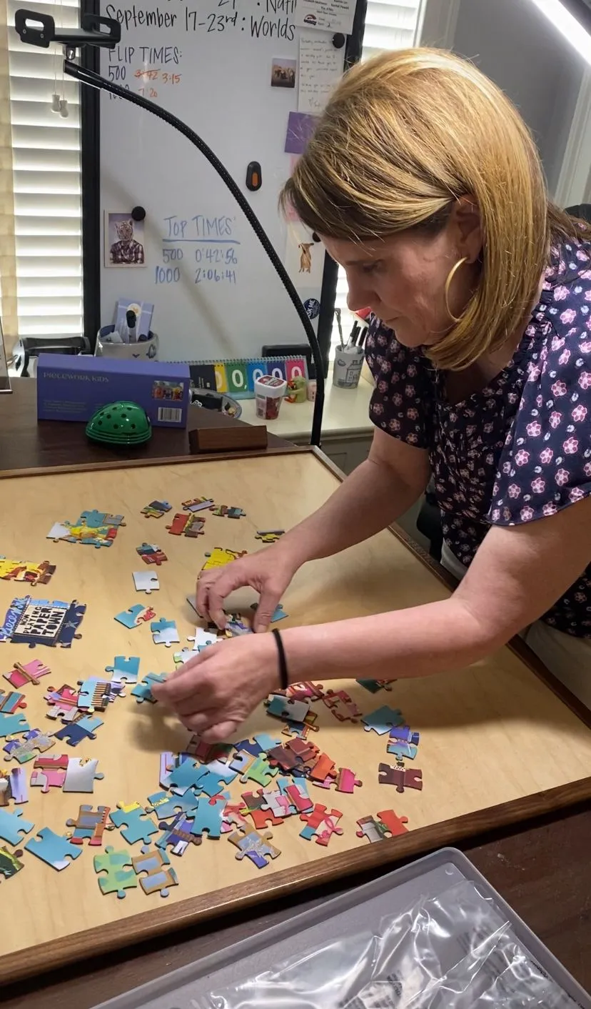 a woman is assembling pieces of a puzzle
