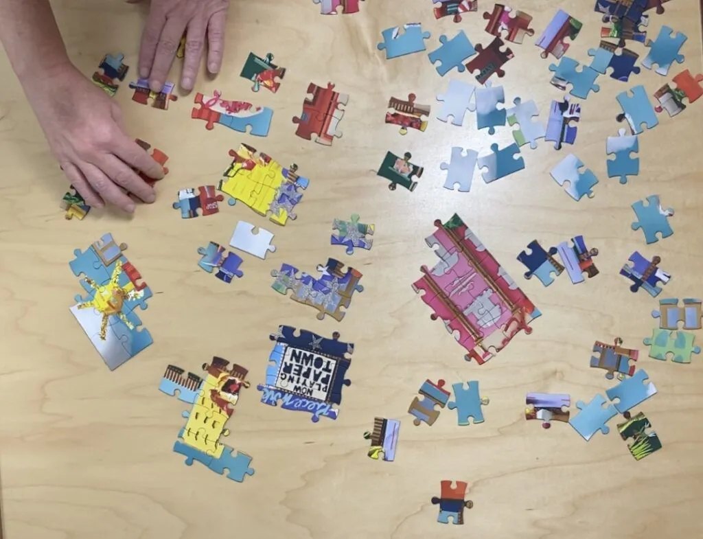 a wooden table topped with lots of puzzle pieces