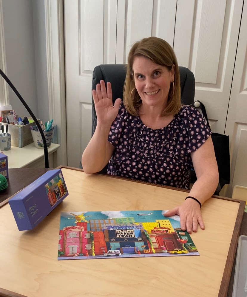 a woman sitting at a desk with a puzzle