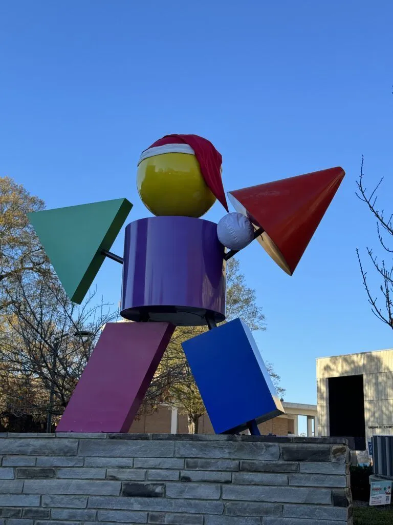 a colorful wind chime on a pole next to a building