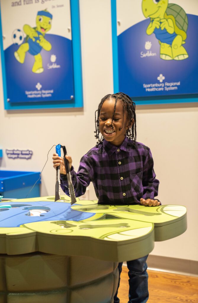 a little girl standing in front of a table