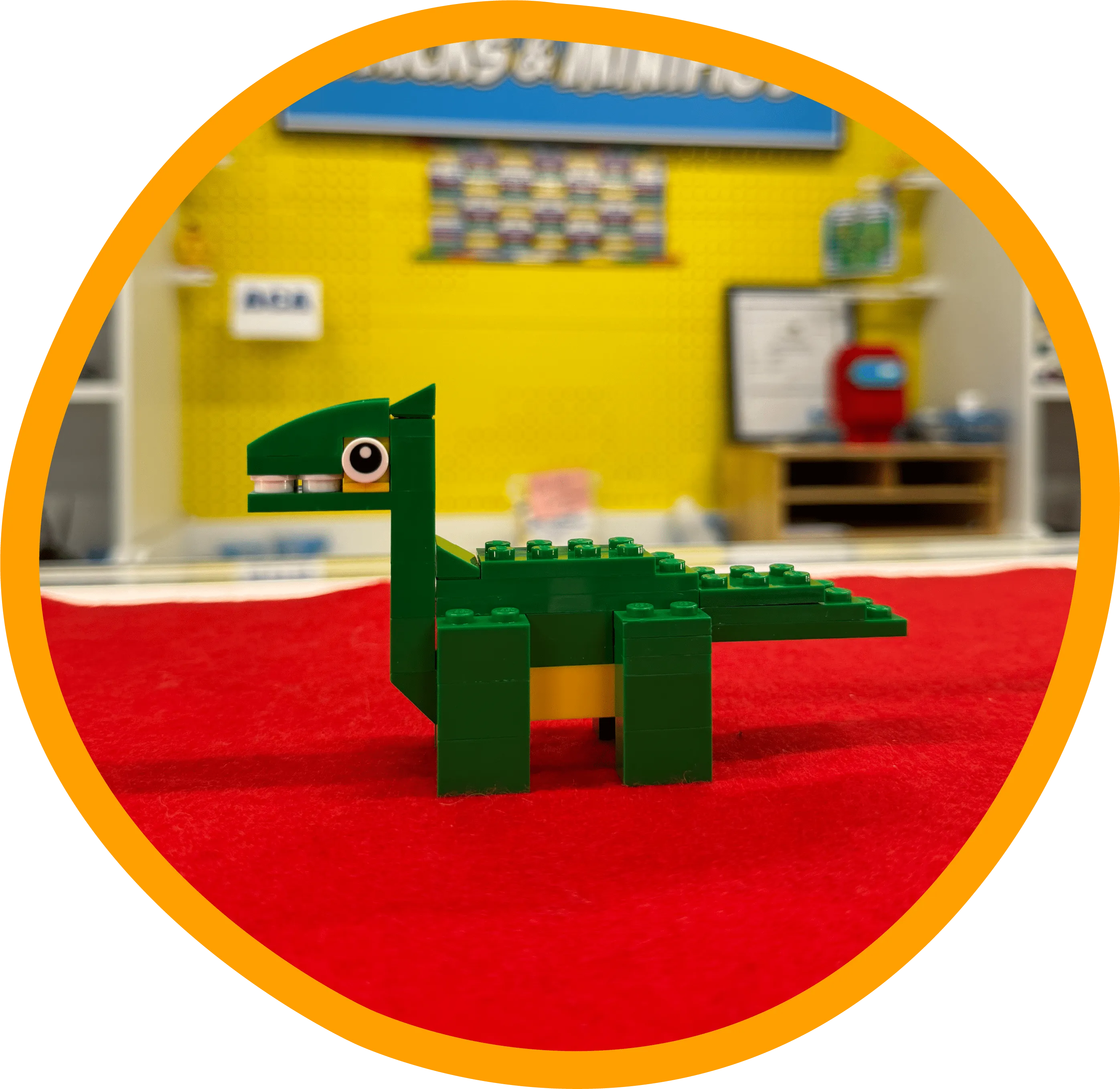 a green lego dinosaur sitting on top of a red carpet