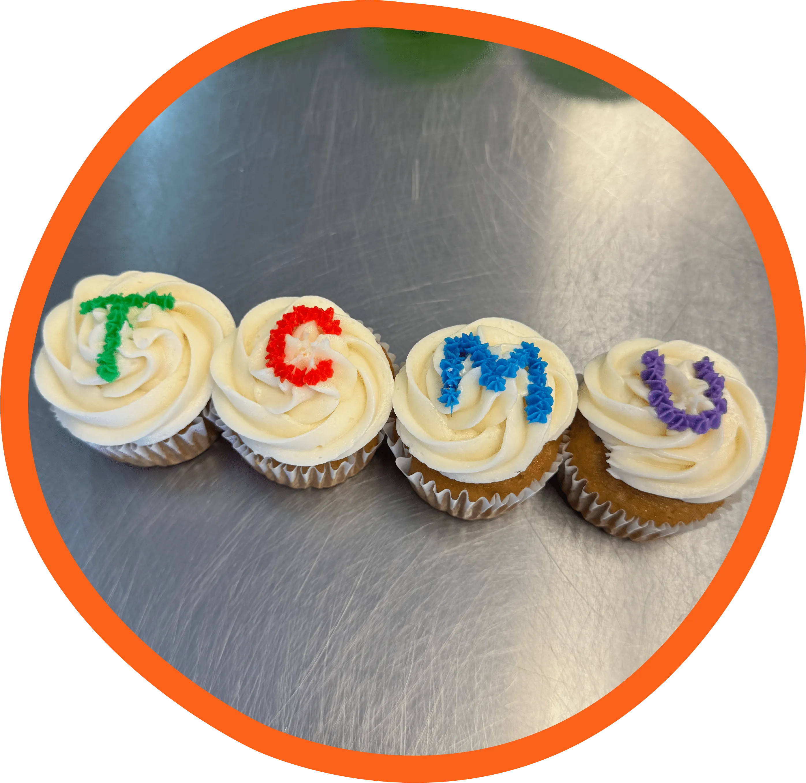 a group of cupcakes with icing in the shape of letters