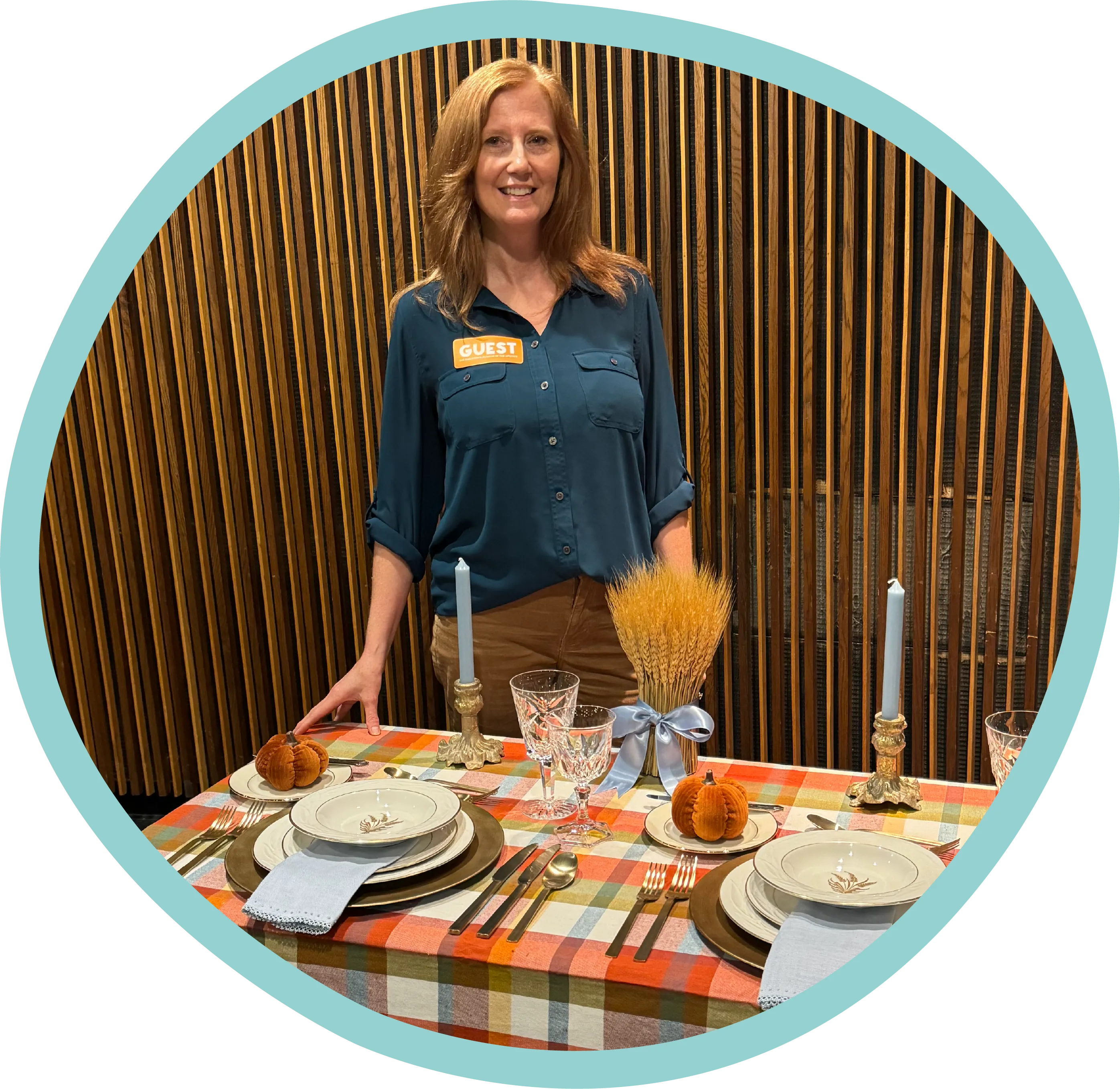 a woman standing in front of a table set for a meal