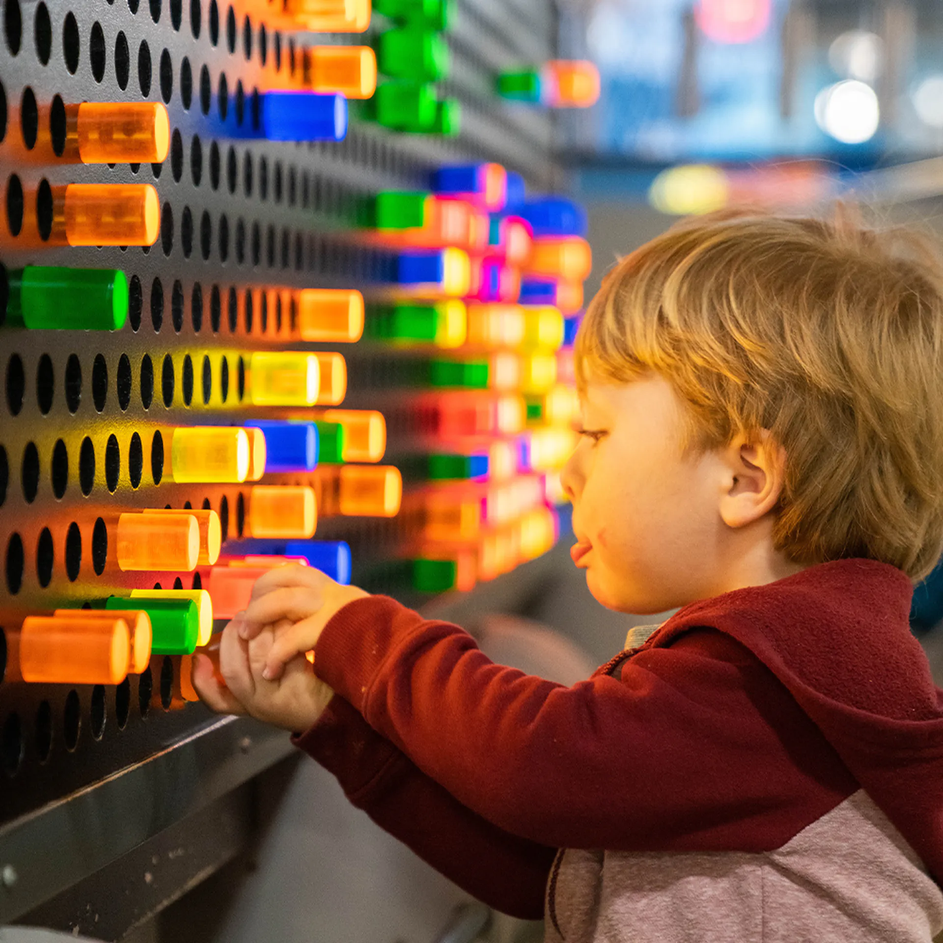 child playing with a lightboard that is colorful at TCMU greenville