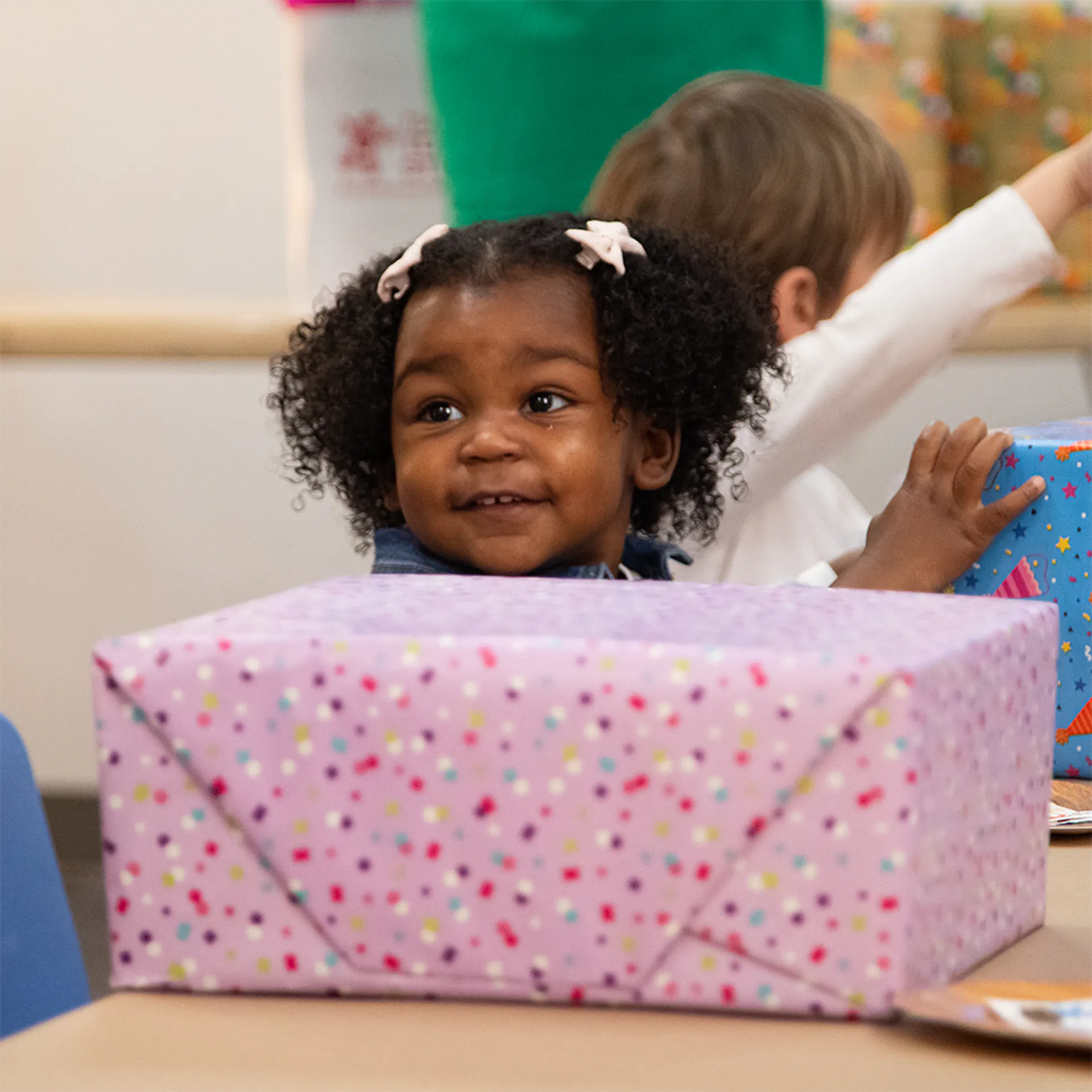 Girl beside a birthday present at the Children's Museum of the Upstate Spartanburg location.