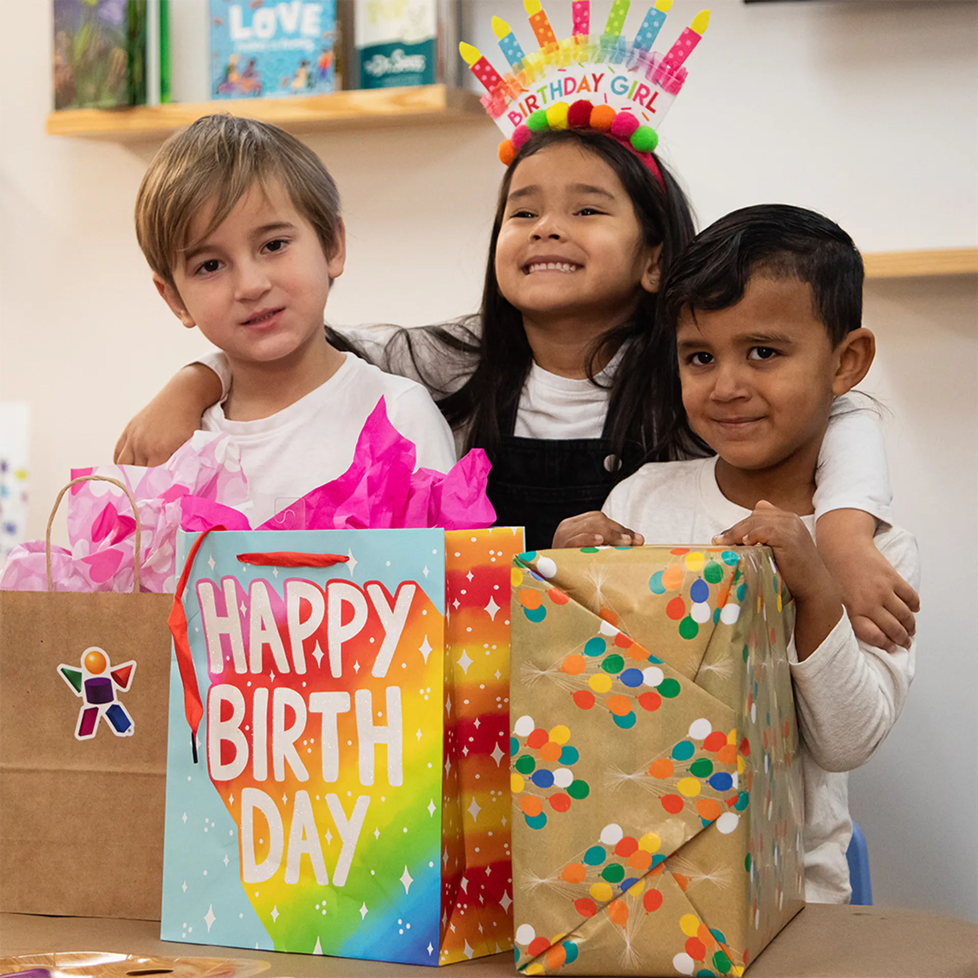 Birthday girl and friends in front of her birthday gifts at the Children's Museum of the Upstate Spartanburg location.