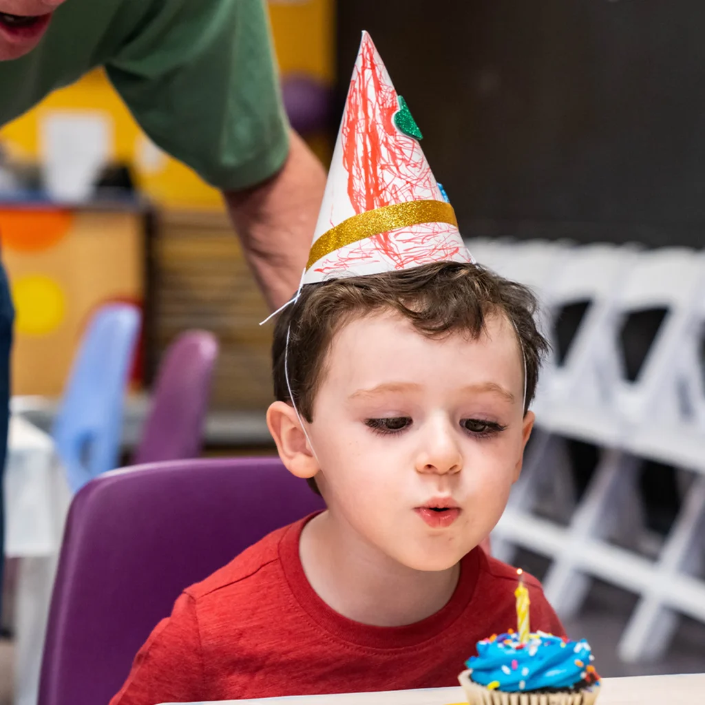 Birthday boy blowing out his candle at the Children's Museum of the Upstate Greenville location.
