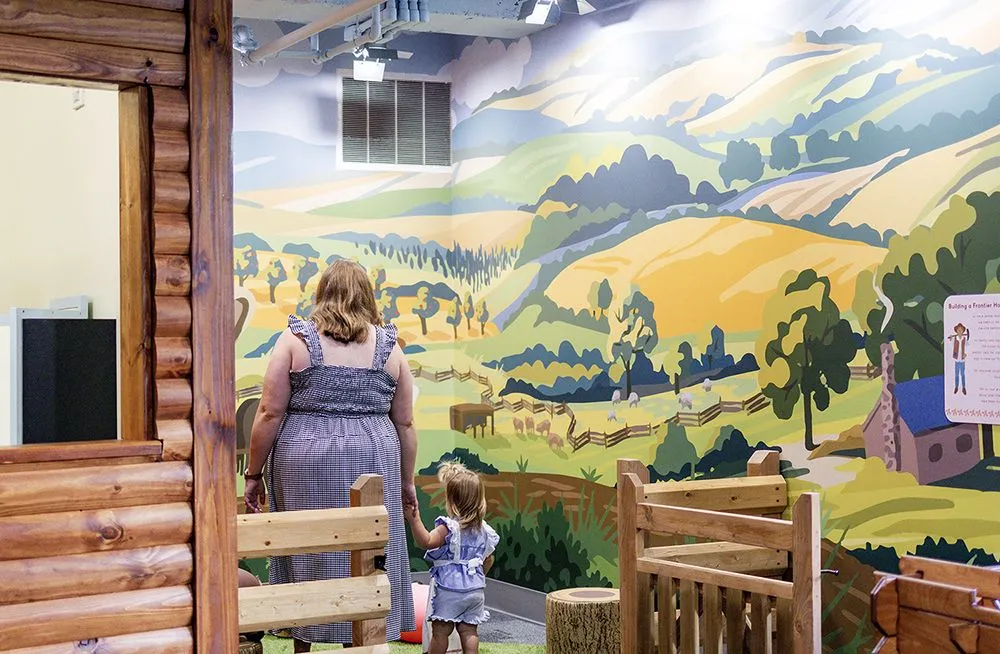 mother walking holding daughters hand in the play farm