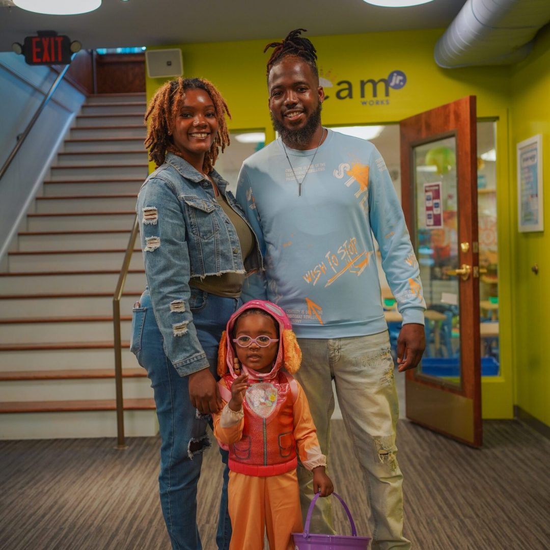 a man and a woman standing in a hallway with a child